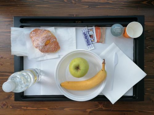 una caja de almuerzo con una manzana y un plato de comida en Sacco Bed&Breakfast, en Rovigo