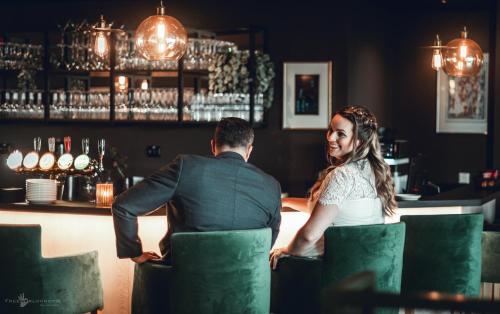 un hombre y una mujer sentados en un bar en Hotell Jæren en Bryne