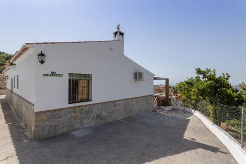 a white building with a fence in front of it at La Monticana in Frigiliana