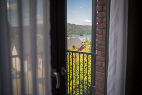an open window with a view of a house at Willa Zdrojowa in Polańczyk