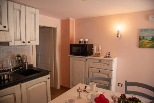 a kitchen with a table and a microwave in it at La Beppa - Casa Vacanza in Pontremoli