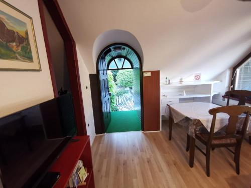 a living room with a table and a green door at Apartmaji Mak in Jesenice