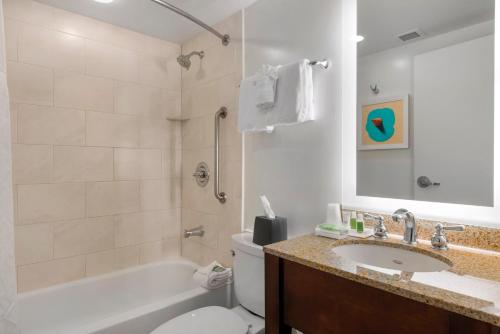 a bathroom with a tub and a toilet and a sink at Holiday Inn Orlando – Disney Springs™ Area, an IHG Hotel in Orlando