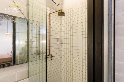 a bathroom with a glass shower with a mirror at Belakang KongHeng By DreamScape in Ipoh
