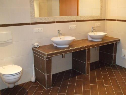 a bathroom with two sinks and a toilet at Ferienwohnung Bongartz in Einbeck