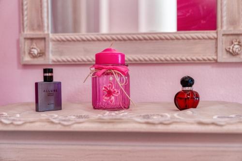 a pink bottle sitting on a shelf with two bottles of perfume at Blue Boutique Apts in Amoudara Herakliou