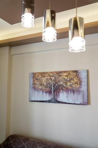 a painting of a tree on a wall with lights at Blue Boutique Apts in Amoudara Herakliou