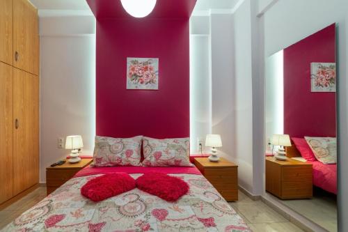 a bedroom with purple walls and a bed with red pillows at Blue Boutique Apts in Amoudara Herakliou
