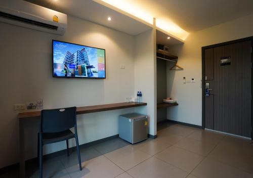 a room with a desk and a tv on the wall at The Zleep Chonburi in Chon Buri