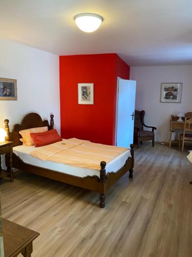 a bedroom with a bed with a red wall at Altstadthotel Wilde Rose in Eppingen