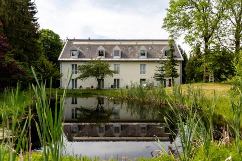 an old house with a pond in front of it at Berghotel Drei Brüder Höhe in Marienberg