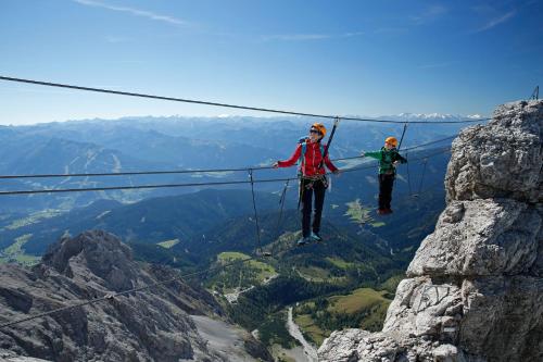 two people on a zip line in the mountains at Naturhotel Lärchenhof in Ramsau am Dachstein