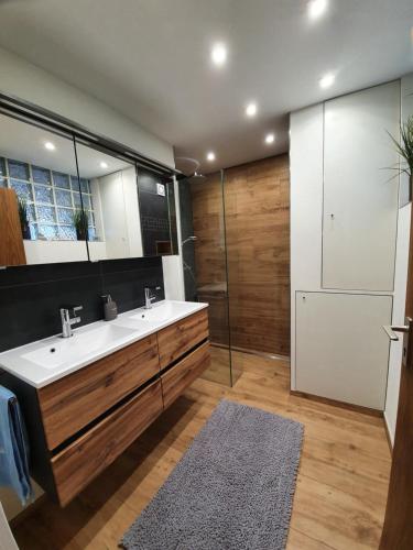 ein Badezimmer mit einem weißen Waschbecken und einer Dusche in der Unterkunft Chickenhill Blackforest, Ferienwohnung Großhans in Bad Wildbad