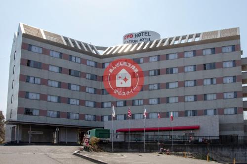 a hotel with a red sign on the front of it at Tabist Yabuki Station Hotel in Yabuki
