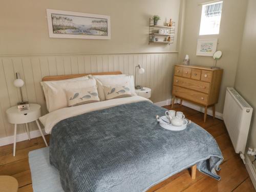 a bedroom with a bed with a blue blanket at Oakridge Cottage in Whitby
