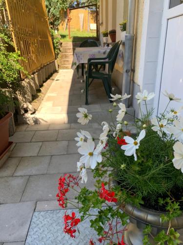 a patio with a table and flowers in a vase at Ferienwohnung Goldener Drache in Hohekreuz