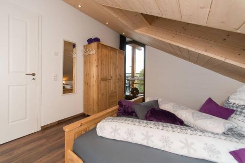 een slaapkamer met een bed met paarse kussens bij Ferienwohnung Kayserlay in Hürtgenwald