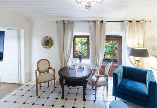 モントルーにあるChâteau du Châtelard | 2 personsのリビングルーム(青いソファ、テーブル、椅子付)
