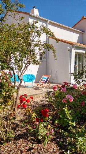 une maison avec une chaise et des fleurs dans la cour dans l'établissement L'Ondine, à Pornic