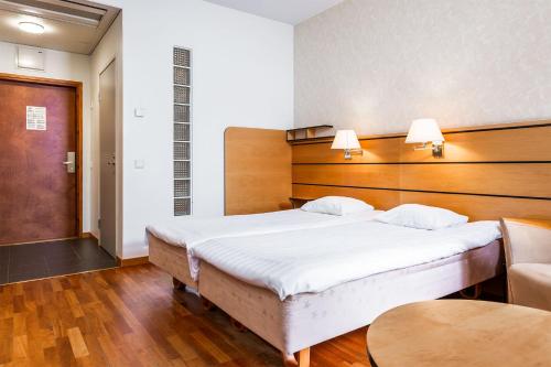 a bedroom with a large bed and a couch at Finlandia Hotel Imatran Kylpylä Spa in Imatra