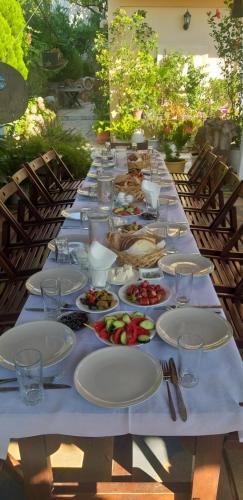 een lange tafel met borden eten erop bij Guesthouse Villa Joanna&Mattheo in Sarandë