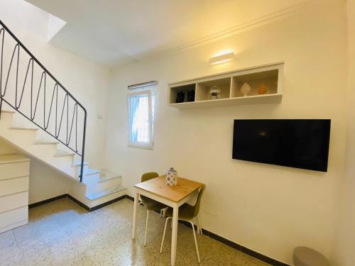 una stanza con un tavolo e una TV su una parete di La Vanedda apartment a Siracusa