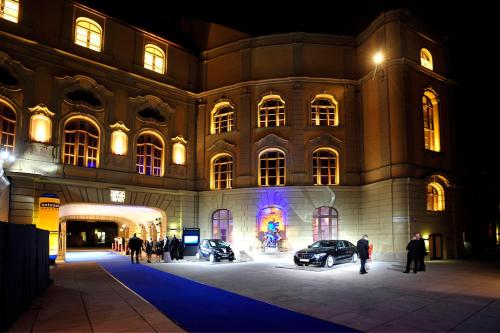 um grande edifício com carros estacionados nele à noite em Hotel Deutsches Theater Stadtzentrum em Munique