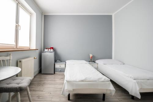 a white room with two beds and a table at Pablo in Niechorze