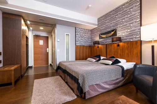 a bedroom with a large bed and a couch at Finlandia Hotel Imatran Kylpylä Spa in Imatra
