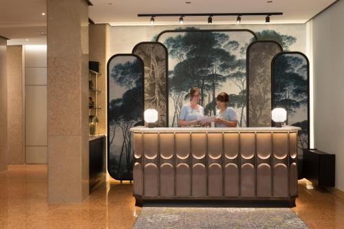 a lobby with a large painting of two women at Hotel Indigo Verona - Grand Hotel Des Arts, an IHG Hotel in Verona