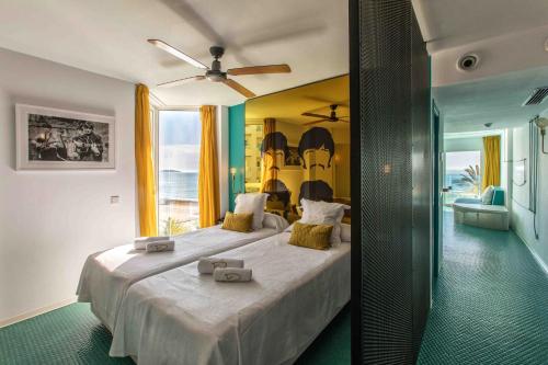 Dorado Ibiza - Adults Only في بلايا ذين بوسا: غرفة نوم بسرير كبير مع مروحة سقف