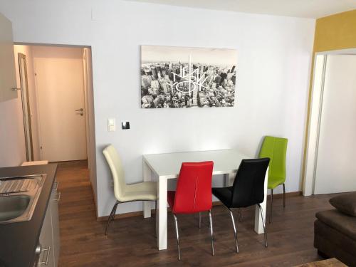 ein Esszimmer mit einem weißen Tisch und 4 Stühlen in der Unterkunft Wohlfühlen in der Altstadt von Steyr in Steyr