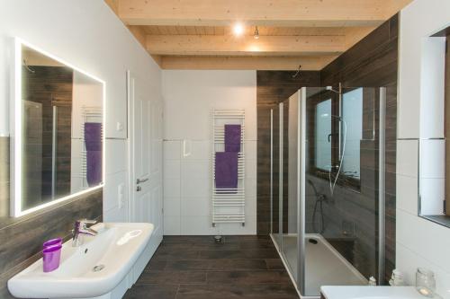 a bathroom with a sink and a tub and a mirror at Ferienwohnung Tiefenbach in Hürtgenwald