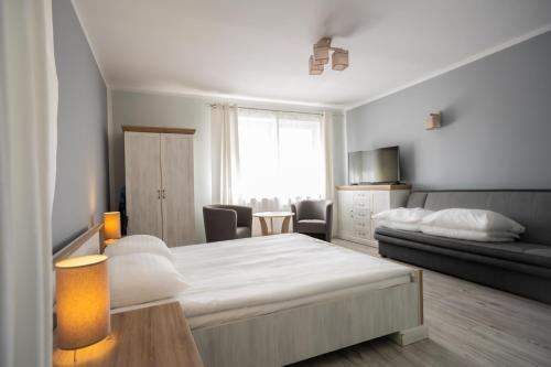 a bedroom with a bed and a living room at Pablo in Niechorze