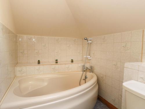 a bathroom with a white tub in a room at Cooinda Flat in Morar