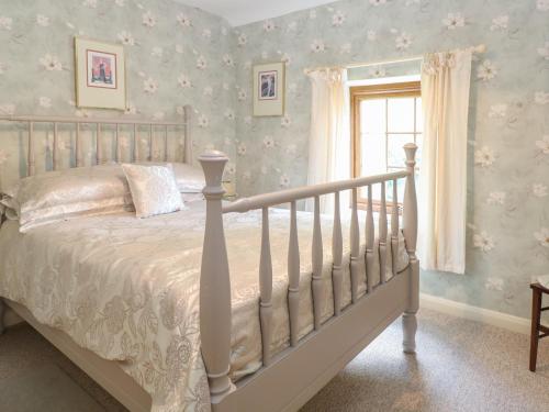 a bedroom with a bed and a window at Willow Cottage in Watton