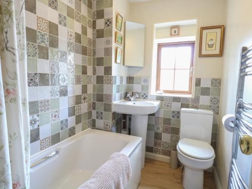 Willow Cottage في Watton: حمام مع حوض ومرحاض ومغسلة