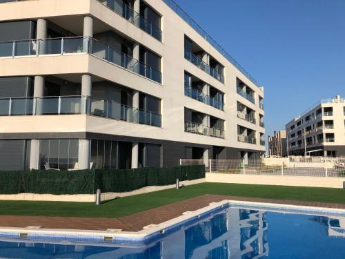 ラ・マタにあるPinada Beach IVのアパートメントの建物の正面にスイミングプールがあります。