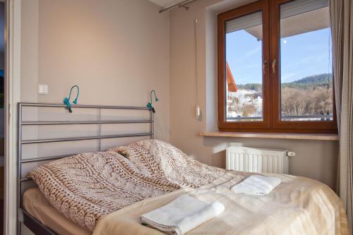 a bedroom with a bed with two towels on it at Aba Apartamenty z parkingiem in Krynica Zdrój