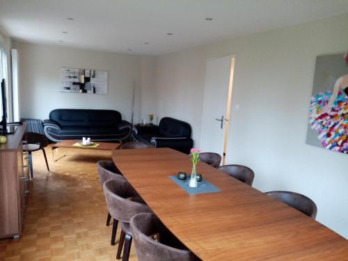 a dining room with a wooden table and chairs at La maison de Paul in Mittelwihr