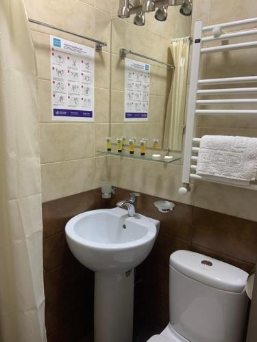a bathroom with a sink and a toilet and a mirror at Sweet Rooms Inn in Tbilisi City