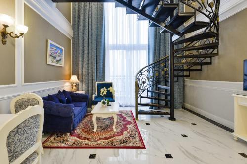 a living room with a blue couch and a spiral staircase at Lan Rung Beach Resort in Long Hai
