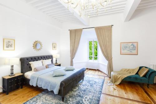 een witte slaapkamer met een bed en een blauw tapijt bij Authentic Middle Ages apartment in the Castle in Clarens