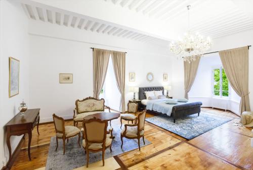 a living room with a bed and a table and chairs at Authentic Middle Ages apartment in the Castle in Clarens