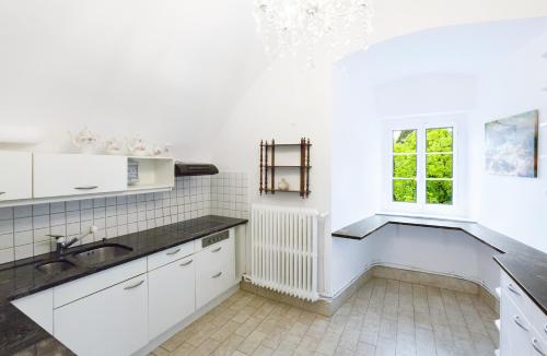 a white kitchen with a sink and a window at Authentic Middle Ages apartment in the Castle in Clarens
