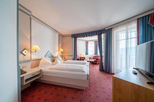 ミルシュタットにあるHotel Alexanderhofのベッドとテレビが備わるホテルルームです。