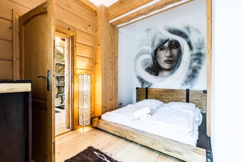 a bedroom with a bed with a painting on the wall at Apartament Harnasiowa Grota in Kościelisko