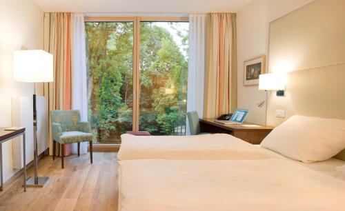 una camera d'albergo con due letti e una finestra di FREIgeist Northeim a Northeim