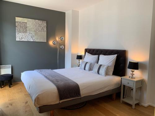 a bedroom with a large bed with a black headboard at Appartement Disneyland au centre du Val d'Europe in Chessy