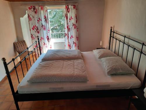 2 camas en un dormitorio con ventana en Casa Laura, en Cevio